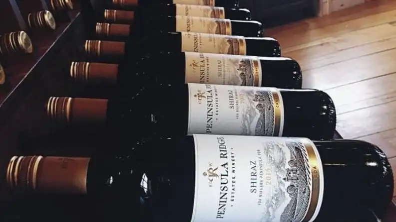 Bottles of Peninsula Ridge 2015 Shiraz lying in a wooden wine rack